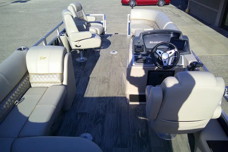 Slide: The Image of 2024 Ranger Reata 220FC pontoon boat interior with plush seating and modern helm. - 9