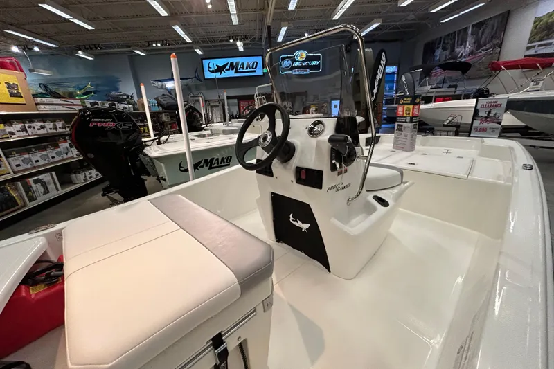 Slide: The Image of 2026 Mako Pro Skiff 15 CC boat interior with steering console in showroom. - 5
