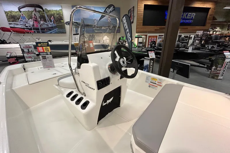 Slide: The Image of 2026 Mako Pro Skiff 15 CC boat interior with steering console in showroom. - 6