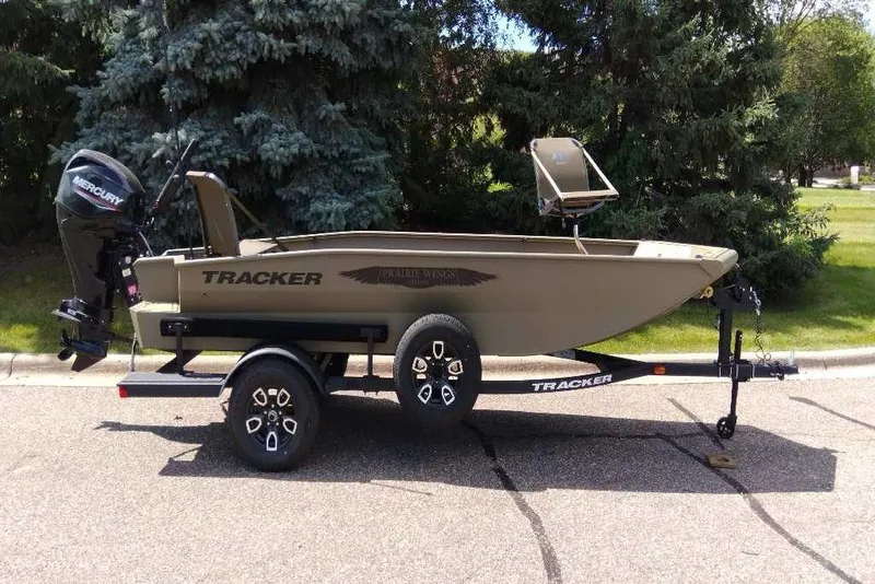 The Image of 2026 Tracker Grizzly 1650 T Prairie Wings Edition boat on trailer, parked outdoors. - 0