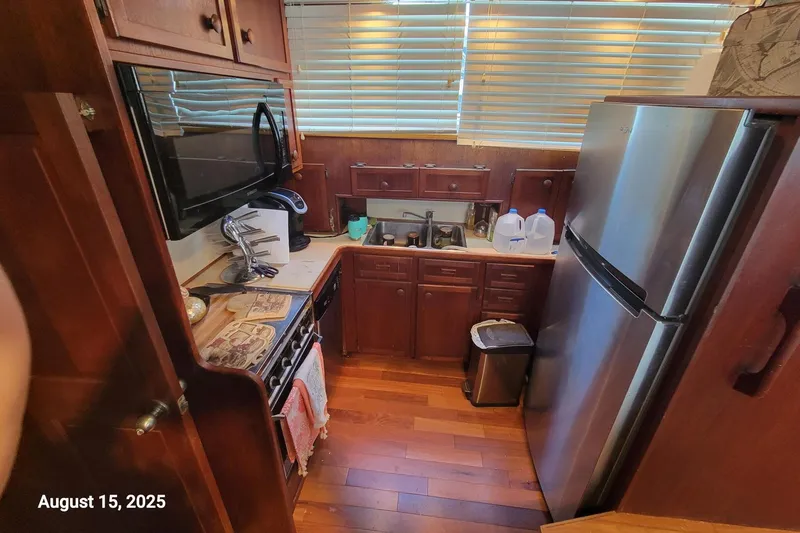Slide: The Image of Compact kitchen in 1985 Chris-Craft 500 Constellation yacht with wooden cabinets and modern appliances. - 21