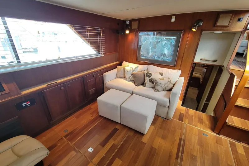 Slide: The Image of 1985 Chris-Craft 500 Constellation interior with cozy seating, wooden flooring, and nautical decor. - 23