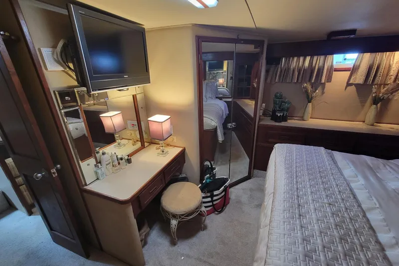 Slide: The Image of Luxurious 1985 Chris-Craft 500 Constellation yacht bedroom with vanity, TV, and elegant decor. - 27
