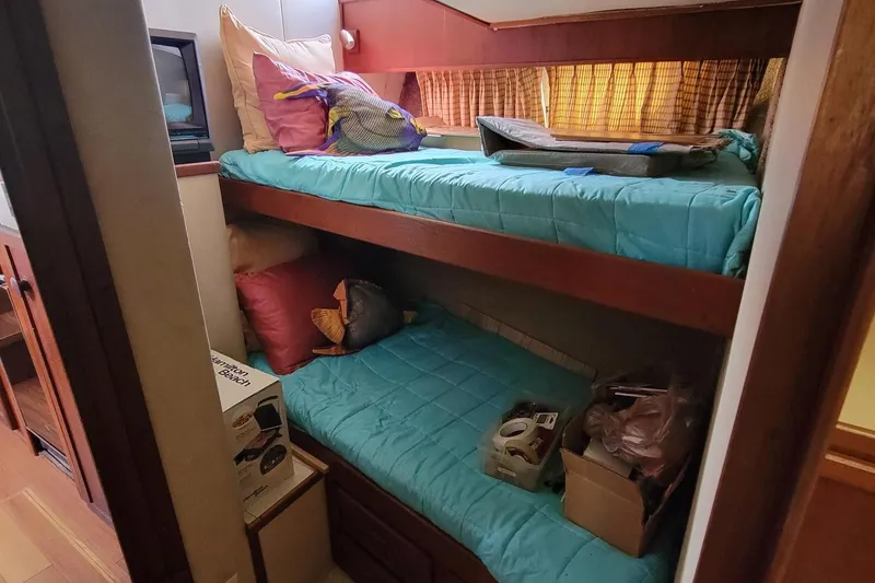 Slide: The Image of 1985 Chris-Craft 500 Constellation cabin with bunk beds and storage boxes. - 38