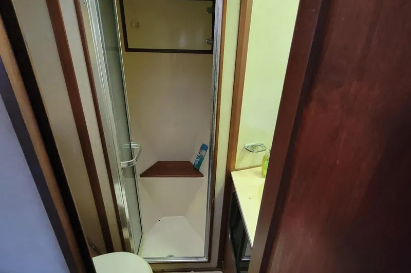 Slide: The Image of 1985 Chris-Craft 500 Constellation yacht bathroom with shower and wooden accents. - 39