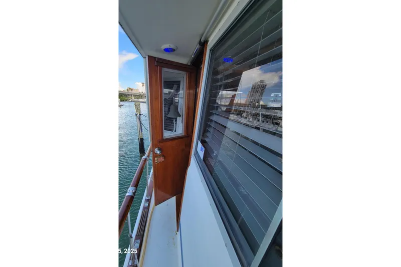 Slide: The Image of 1985 Chris-Craft 500 Constellation yacht deck with wooden door and waterfront view. - 51
