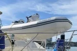 Slide: The Image of 1985 Chris-Craft 500 Constellation yacht with inflatable boat on deck, under clear sky. - 56