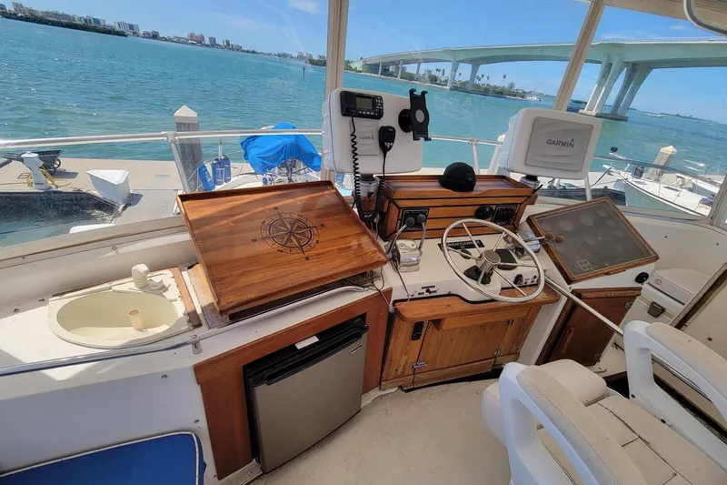 Slide: The Image of 1985 Chris-Craft 500 Constellation helm with navigation equipment, overlooking scenic waterfront and bridge. - 6