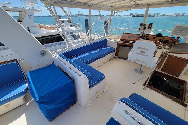 Slide: The Image of 1985 Chris-Craft 500 Constellation yacht interior with blue seating and helm, overlooking water. - 8