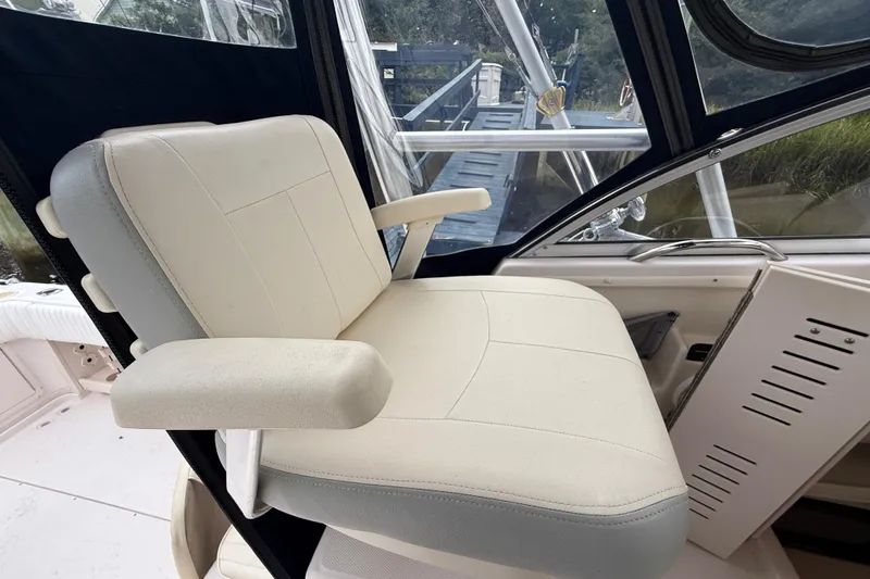 Slide: The Image of Captain's chair on 2003 Grady-White Sailfish 282 boat, featuring beige upholstery and armrests. - 18