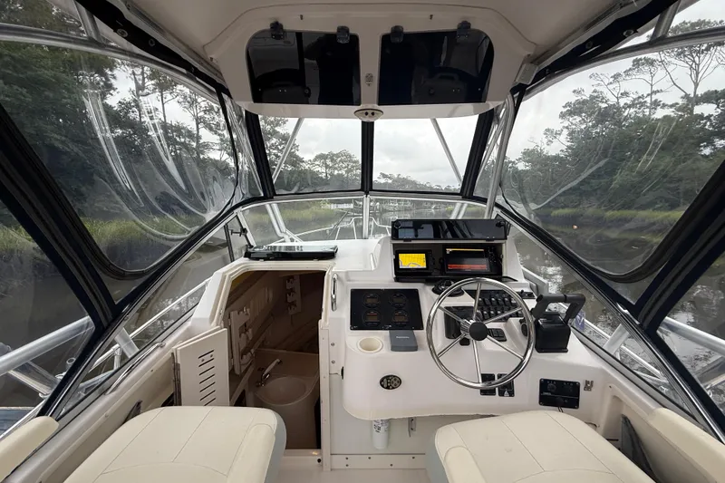 Slide: The Image of 2003 Grady-White Sailfish 282 boat interior with steering wheel and navigation equipment. - 19