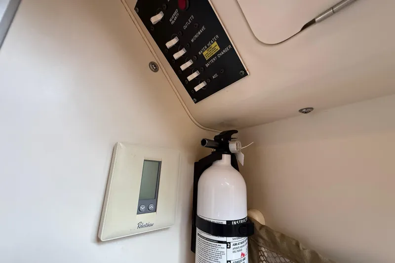 Slide: The Image of 2003 Grady-White Sailfish 282 interior with control panel and fire extinguisher. - 23