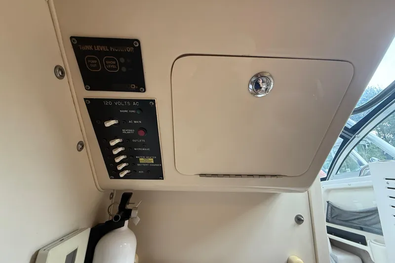 Slide: The Image of 2003 Grady-White Sailfish 282 interior control panel with tank level monitor and AC switches. - 24