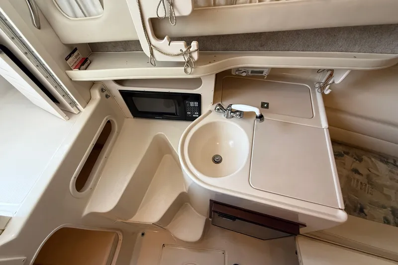 Slide: The Image of 2003 Grady-White Sailfish 282 boat interior with sink, microwave, and storage. - 27