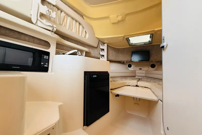 Slide: The Image of Interior of 2003 Grady-White Sailfish 282 boat with microwave, fridge, and cozy sleeping area. - 28