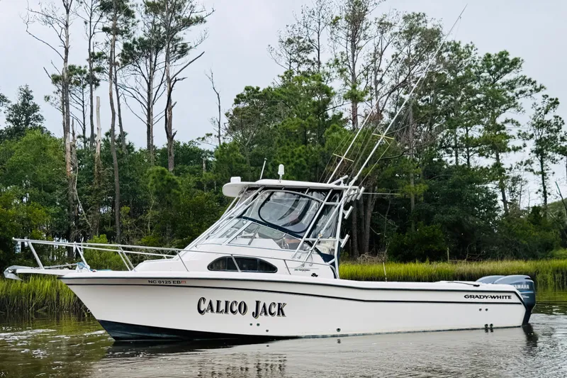 Slide: The Image of 2003 Grady-White Sailfish 282 boat named "Calico Jack" on calm water near trees. - 3