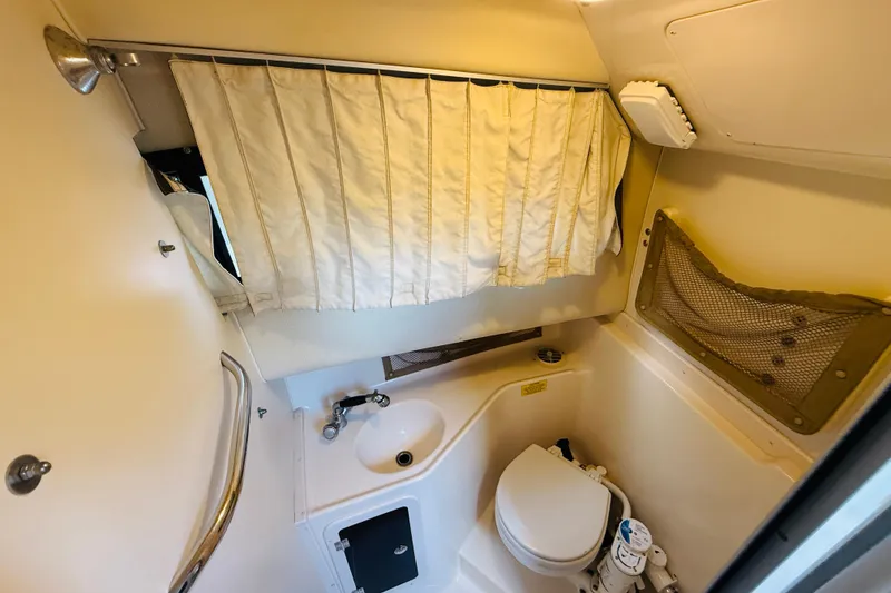 Slide: The Image of 2003 Grady-White Sailfish 282 boat bathroom with sink, toilet, and curtain. - 30
