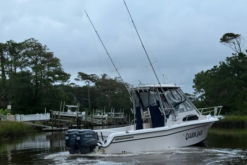 Slide: The Image of 2003 Grady-White Sailfish 282 boat navigating a narrow waterway, surrounded by lush greenery. - 5