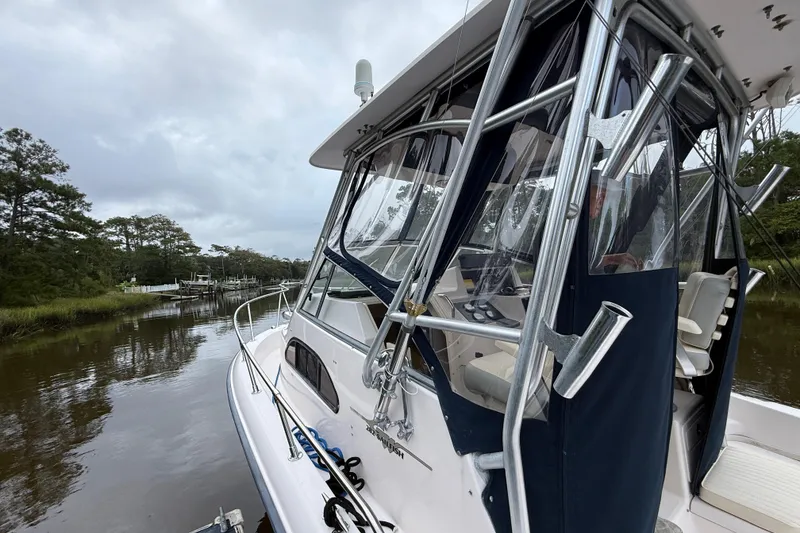 Slide: The Image of 2003 Grady-White Sailfish 282 boat docked on a calm river with lush greenery. - 7