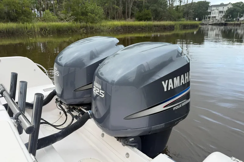 Slide: The Image of Twin Yamaha 225 engines on a 2003 Grady-White Sailfish 282 boat, docked by a serene river. - 9