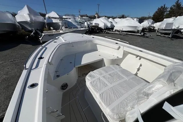 Slide: The Image of 2025 Parker 2600 Center Console boat, white interior, parked among covered boats. - 34