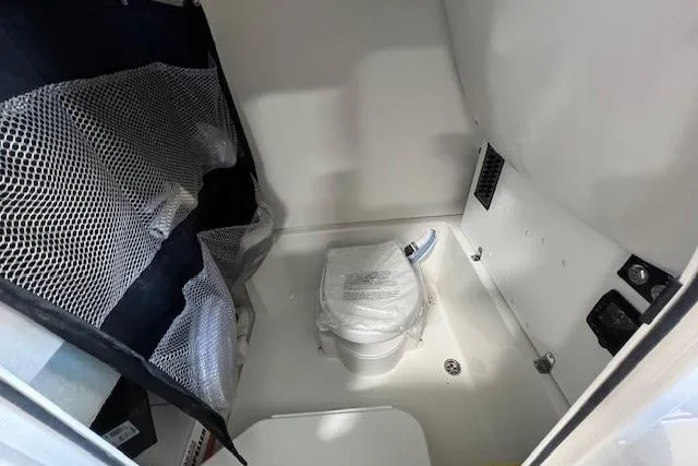 Slide: The Image of 2025 Parker 2600 Center Console boat interior with compact marine toilet and storage net. - 5