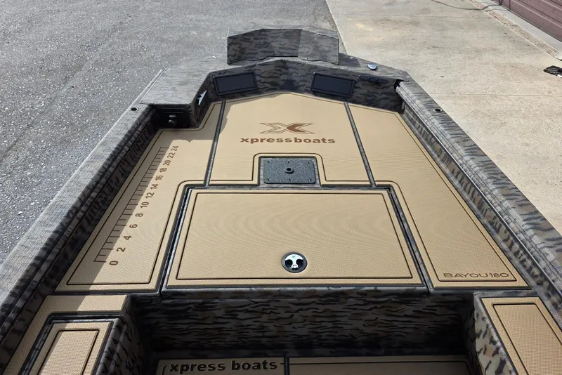 Slide: The Image of 2026 Xpress Bayou 180 boat interior with camo design and measurement markings. - 11