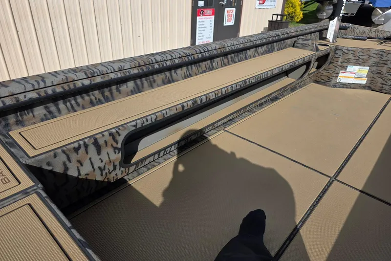 Slide: The Image of 2026 Xpress Bayou 180 boat interior with camouflage design and seating area. - 16
