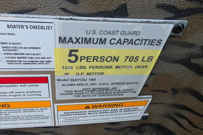 Slide: The Image of U.S. Coast Guard capacity plate for 2026 Xpress Bayou 180, 5-person, 705 lb limit. - 17