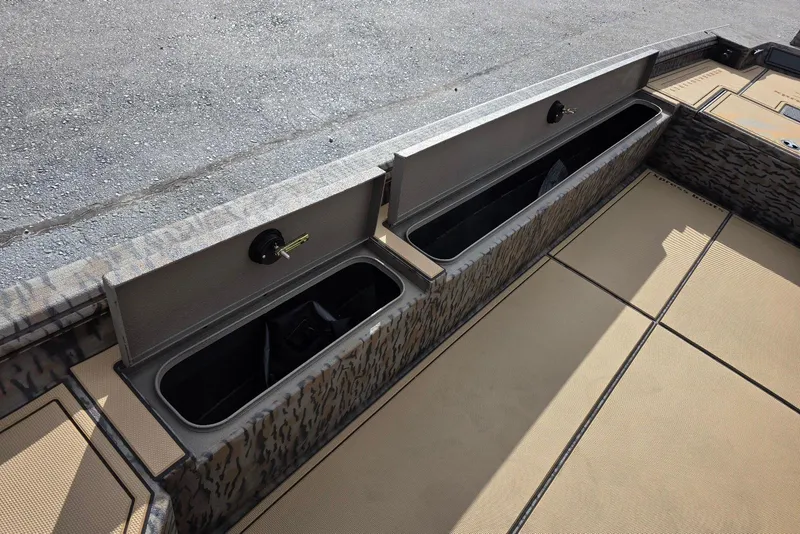 Slide: The Image of 2026 Xpress Bayou 180 boat storage compartments with open lids, showcasing interior space. - 21