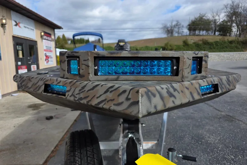 Slide: The Image of 2026 Xpress Bayou 180 boat with camouflage design and blue LED lights. - 4
