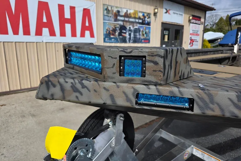 Slide: The Image of 2026 Xpress Bayou 180 boat with camouflage design and blue LED lights. - 5