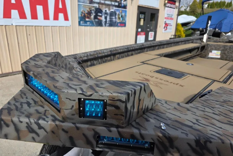 Slide: The Image of 2026 Xpress Bayou 180 boat with camouflage design and blue LED lights. - 6