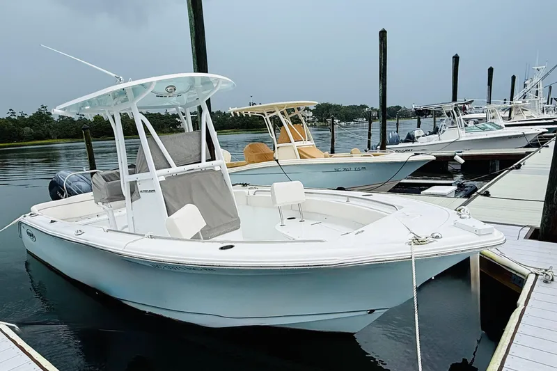 Slide: The Image of 2024 Sea Hunt Ultra 229 boat docked at marina, featuring sleek design and modern amenities. - 4