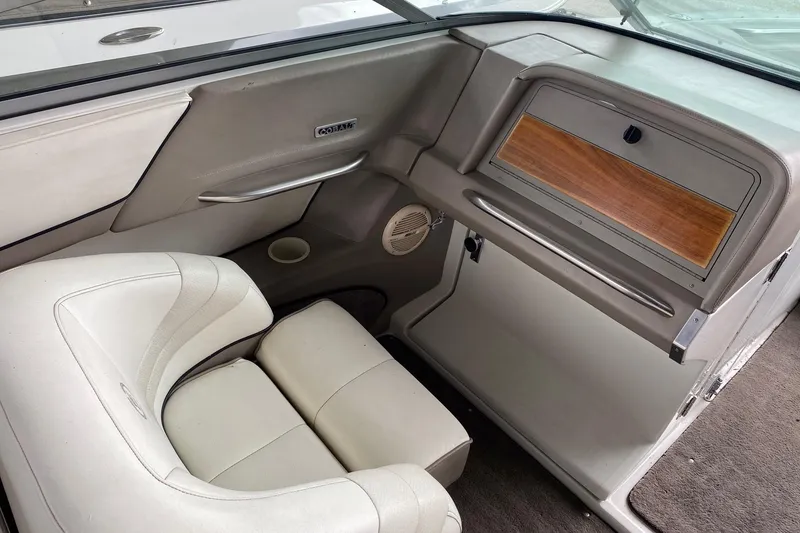 Slide: The Image of Interior of a 1999 Cobalt 252 boat with beige seating and wood accents. - 7