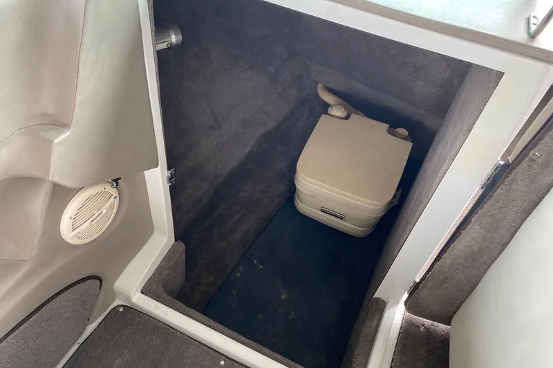 Slide: The Image of Interior of a 1999 Cobalt 252 boat showing a compact portable toilet. - 8
