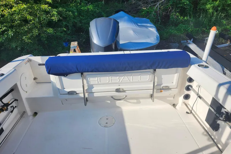 Slide: The Image of 2015 Robalo R245 Walkaround boat interior with blue seat cover and fishing rod holders. - 12