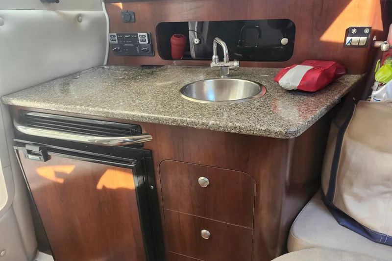 Slide: The Image of 2015 Robalo R245 Walkaround boat interior with kitchenette, sink, and storage. - 5