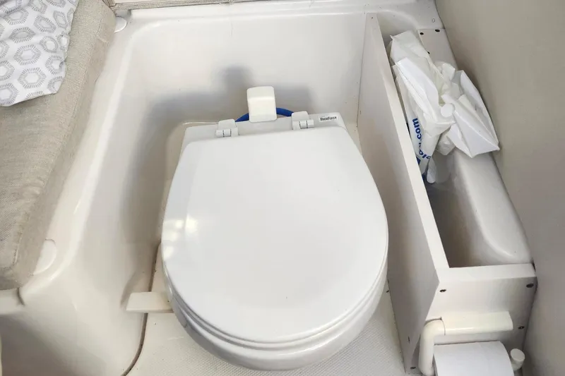 Slide: The Image of 2015 Robalo R245 Walkaround boat toilet with storage compartment and cushion seating. - 7