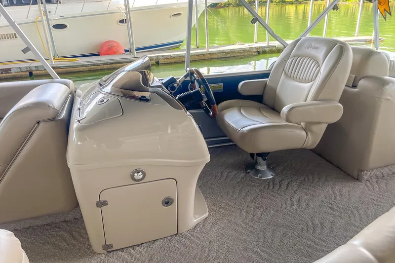 Slide: The Image of Interior of 2011 Berkshire 263 SLX boat with beige seating and steering console. - 11