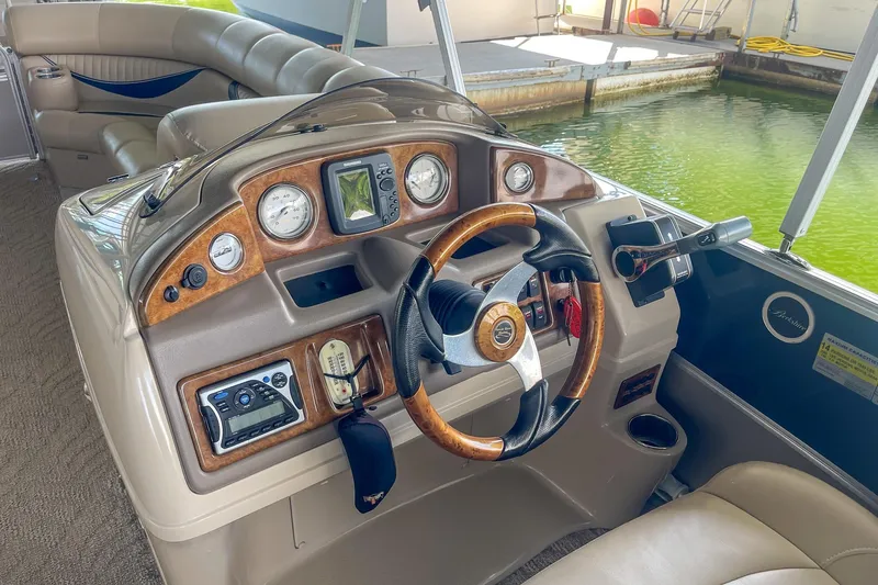 Slide: The Image of 2011 Berkshire 263 SLX boat dashboard with steering wheel and control panel. - 13