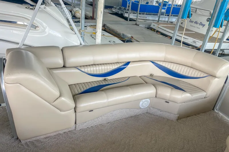 Slide: The Image of Luxurious seating on a 2011 Berkshire 263 SLX boat, featuring beige and blue upholstery. - 24