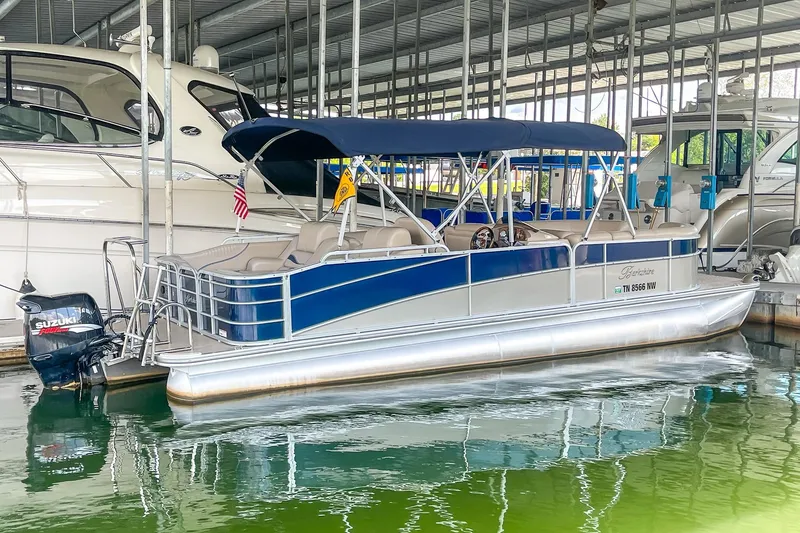 Slide: The Image of 2011 Berkshire 263 SLX pontoon boat docked with blue canopy and Suzuki outboard motor. - 3