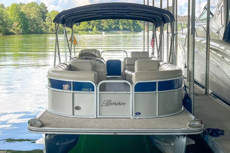 Slide: The Image of 2011 Berkshire 263 SLX pontoon boat docked on a serene lake. - 8