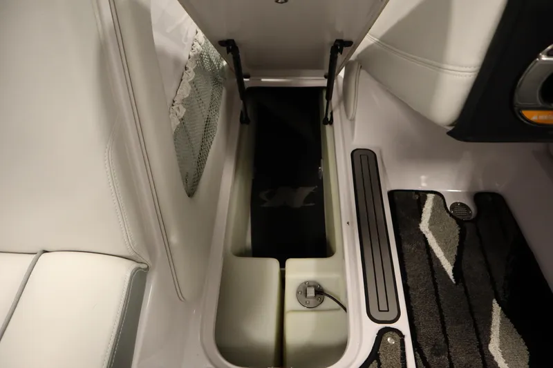 Slide: The Image of 2011 Nautique 210 SUPER AIR interior storage compartment with open lid and carpeted flooring. - 29