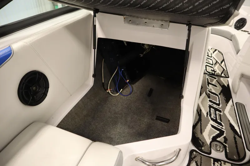 Slide: The Image of 2011 Nautique 210 SUPER AIR interior storage compartment with speaker and carpeted flooring. - 33