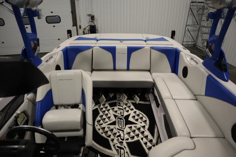 Slide: The Image of 2011 Nautique 210 SUPER AIR boat interior with blue and white seating, stylish design. - 35