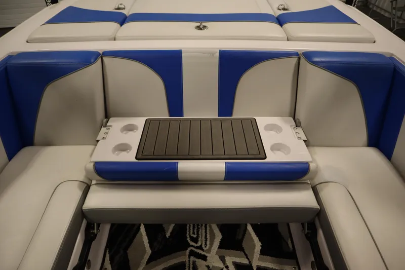 Slide: The Image of 2011 Nautique 210 SUPER AIR boat interior with blue and white seating and cup holders. - 37