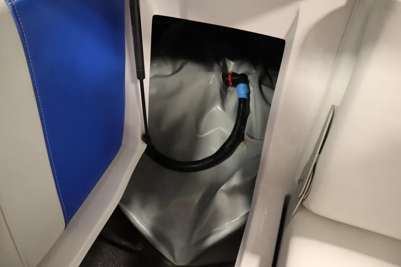 Slide: The Image of 2011 Nautique 210 SUPER AIR boat interior storage compartment with hose and blue upholstery. - 41