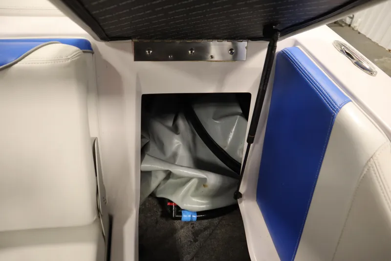 Slide: The Image of Open storage compartment in 2011 Nautique 210 SUPER AIR boat with blue and white seating. - 42